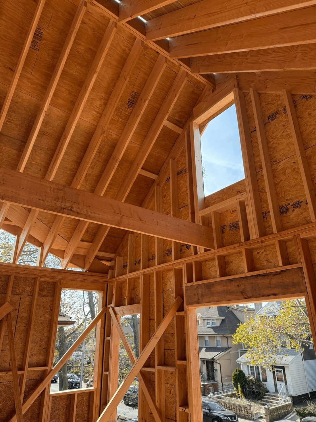 Open roof frame with new rafters and plywood sheathing